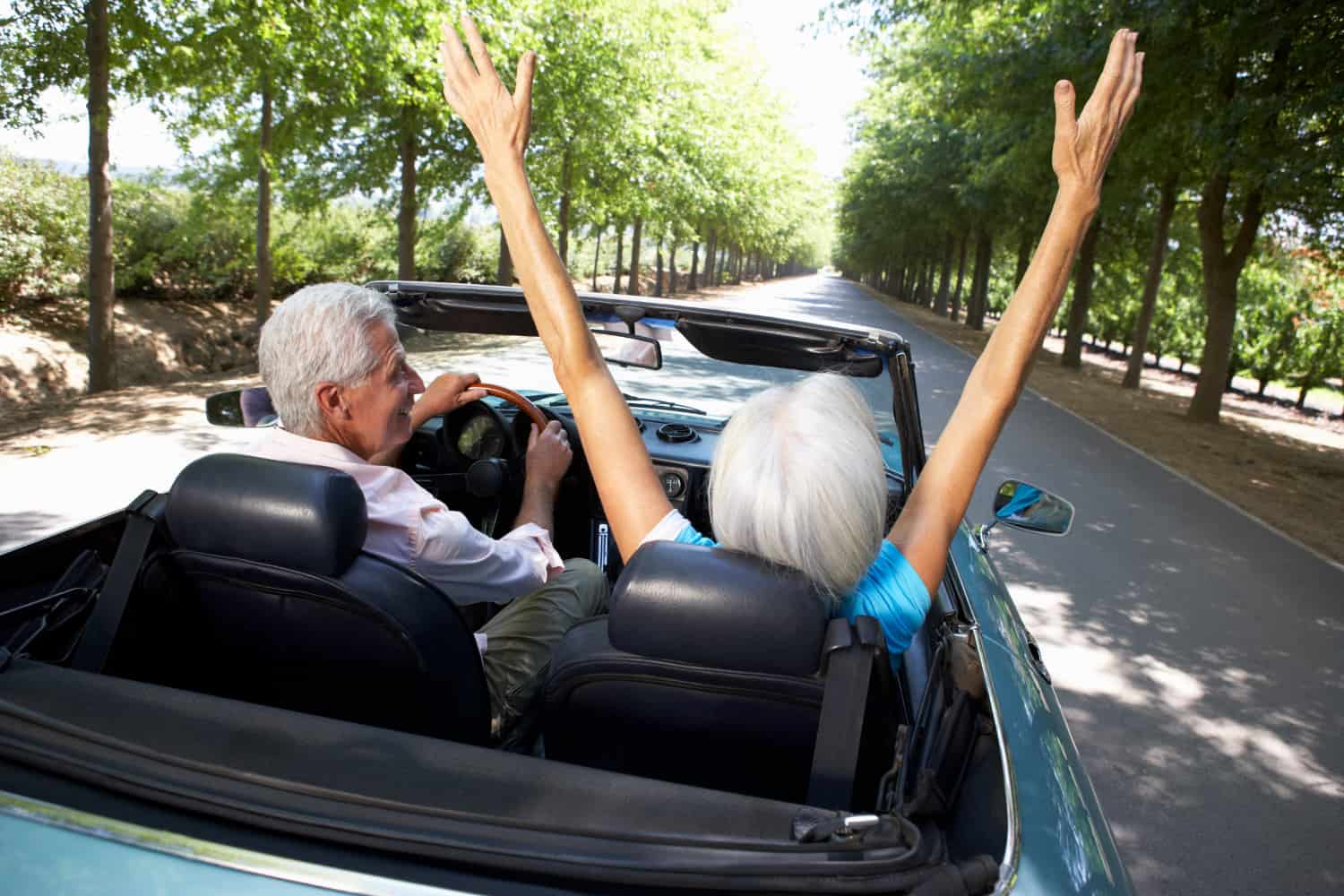 Happy couple driving in convertible