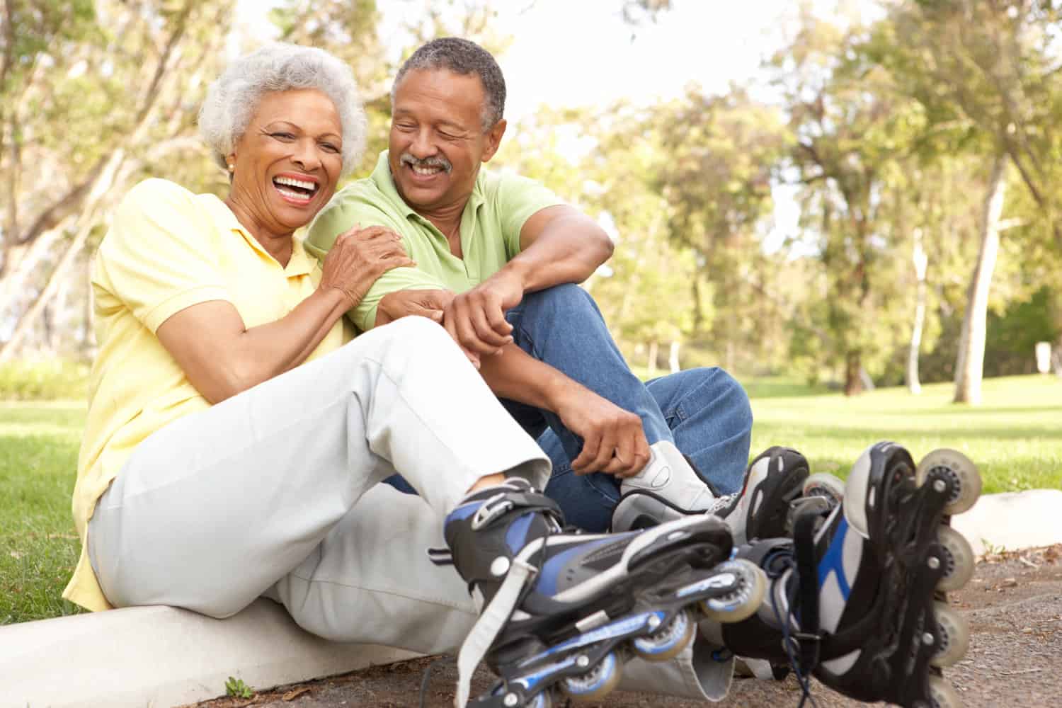 Happy retired couple in park rollerblading