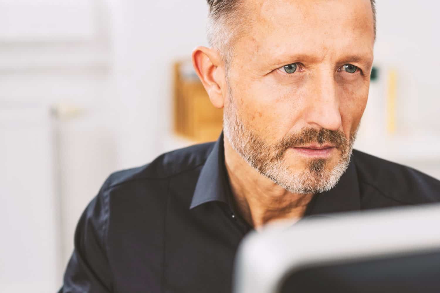 Retired man looking at an article on his laptop