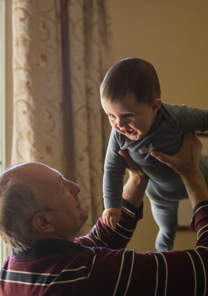 A grandpa holding up his grandchild
